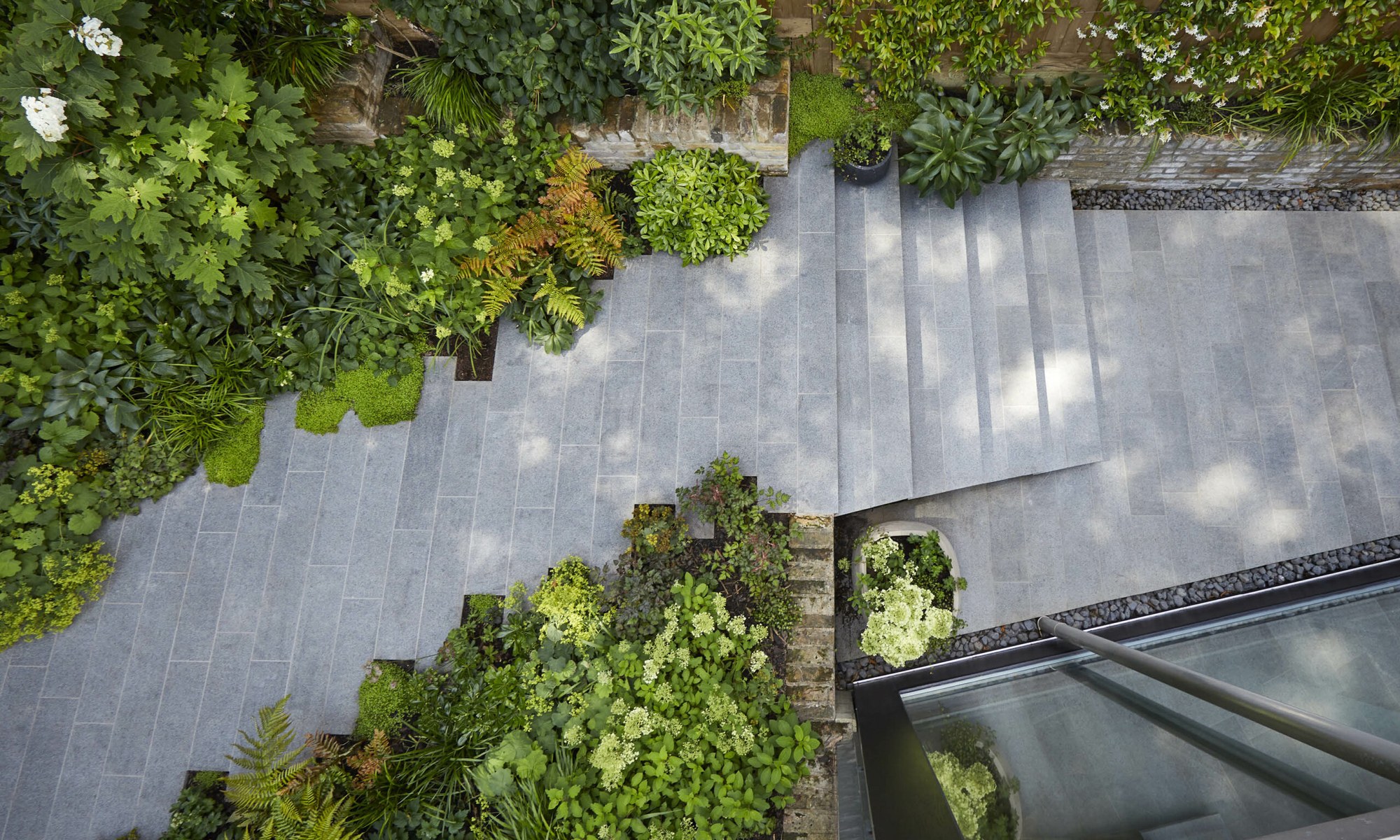 Stone paving and steps built by Shoots & Leaves, edged with soft green planting